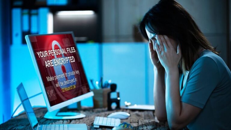 Stressed woman looking at a computer screen showing a ransomware warning, symbolising the risks of neglecting managed IT services.