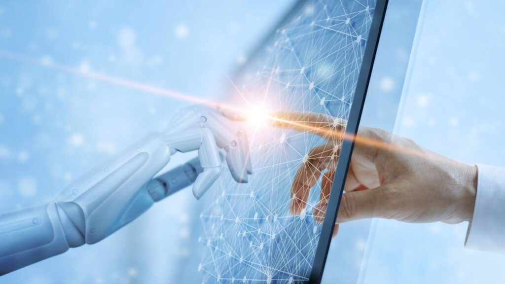 A robotic hand and a human hand connecting through a digital screen, representing the role of AI in modern cybersecurity.