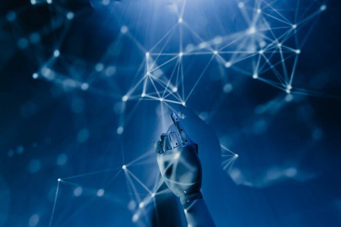 Robotic hand reaching toward a digital network, symbolising AI tools and technology in 2025.