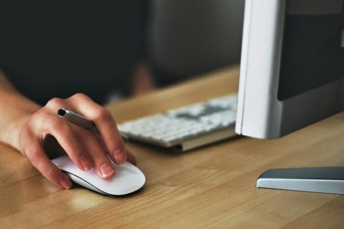 Person using a computer mouse at a desk, representing Microsoft 365 security add-ons.