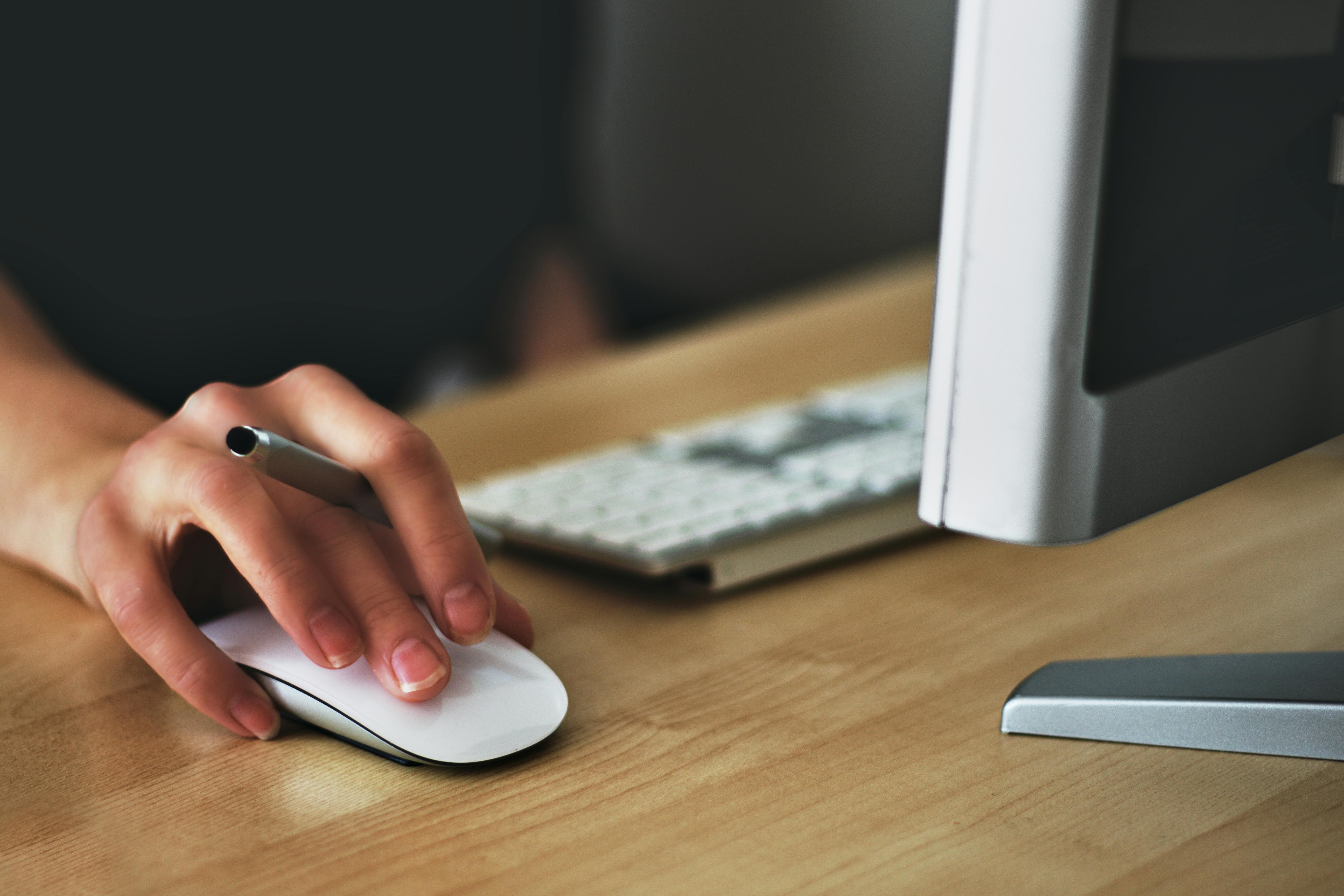 Person using a computer mouse at a desk, representing Microsoft 365 security add-ons.