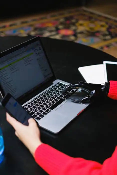 Business user working on a laptop while a robotic hand interacts with data, illustrating AI security risks in the workplace.